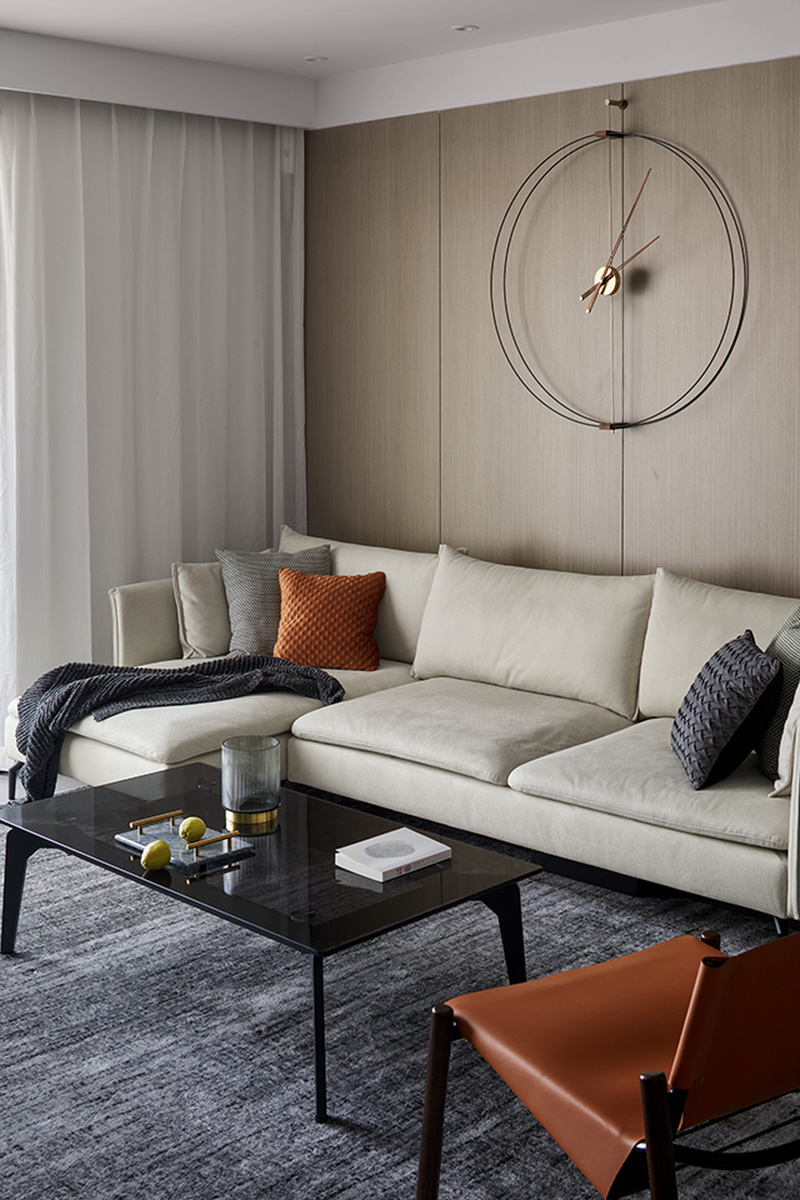 客厅中一抹亮丽的橘色打破了空间的沉闷感使空间充满活力，现代极简的挂钟设计，营造一种时尚前卫的会客环境。