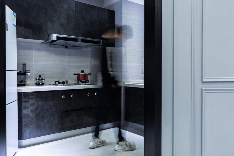 厨房采用黑色岩板的材质作为橱柜的整体色调，让空间的黑白对比更加的明显。