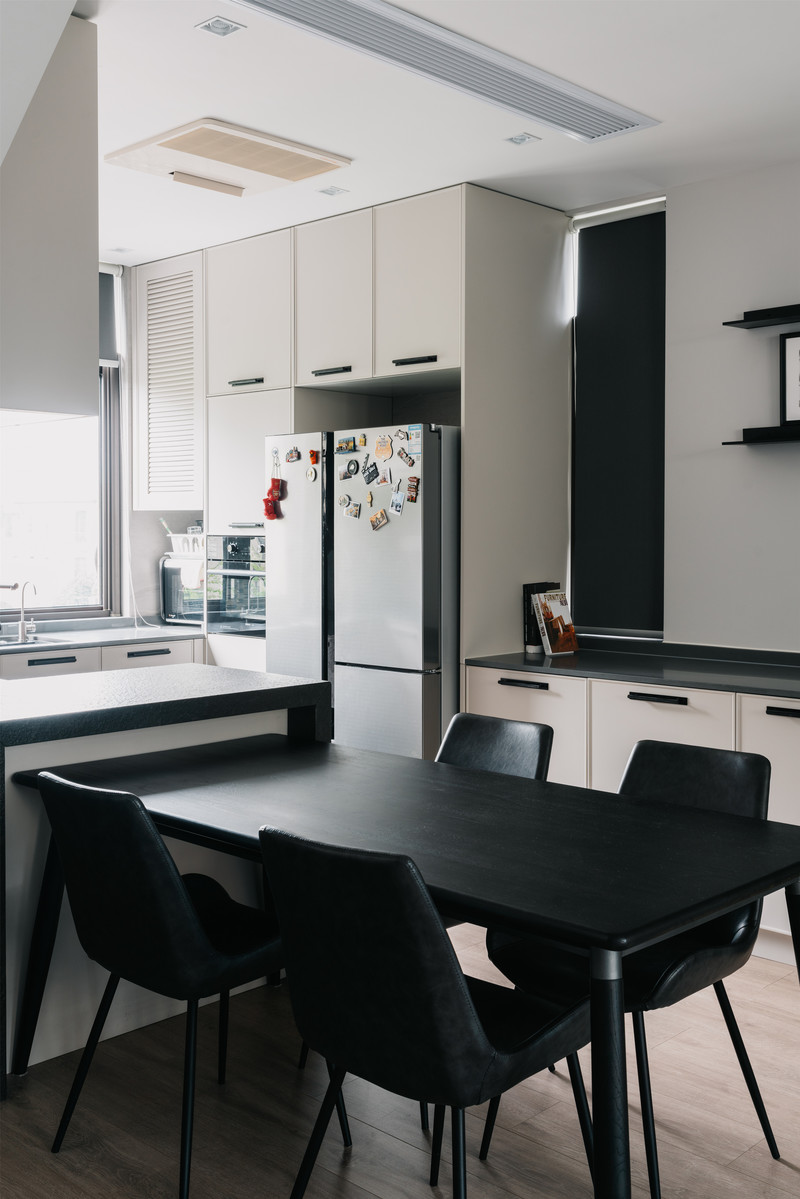 黑色餐桌呼应空间的黑色元素，设置一个小水槽在餐厅空间，延伸了厨房的操作之外，也让家庭成员在用餐前方便洗手。