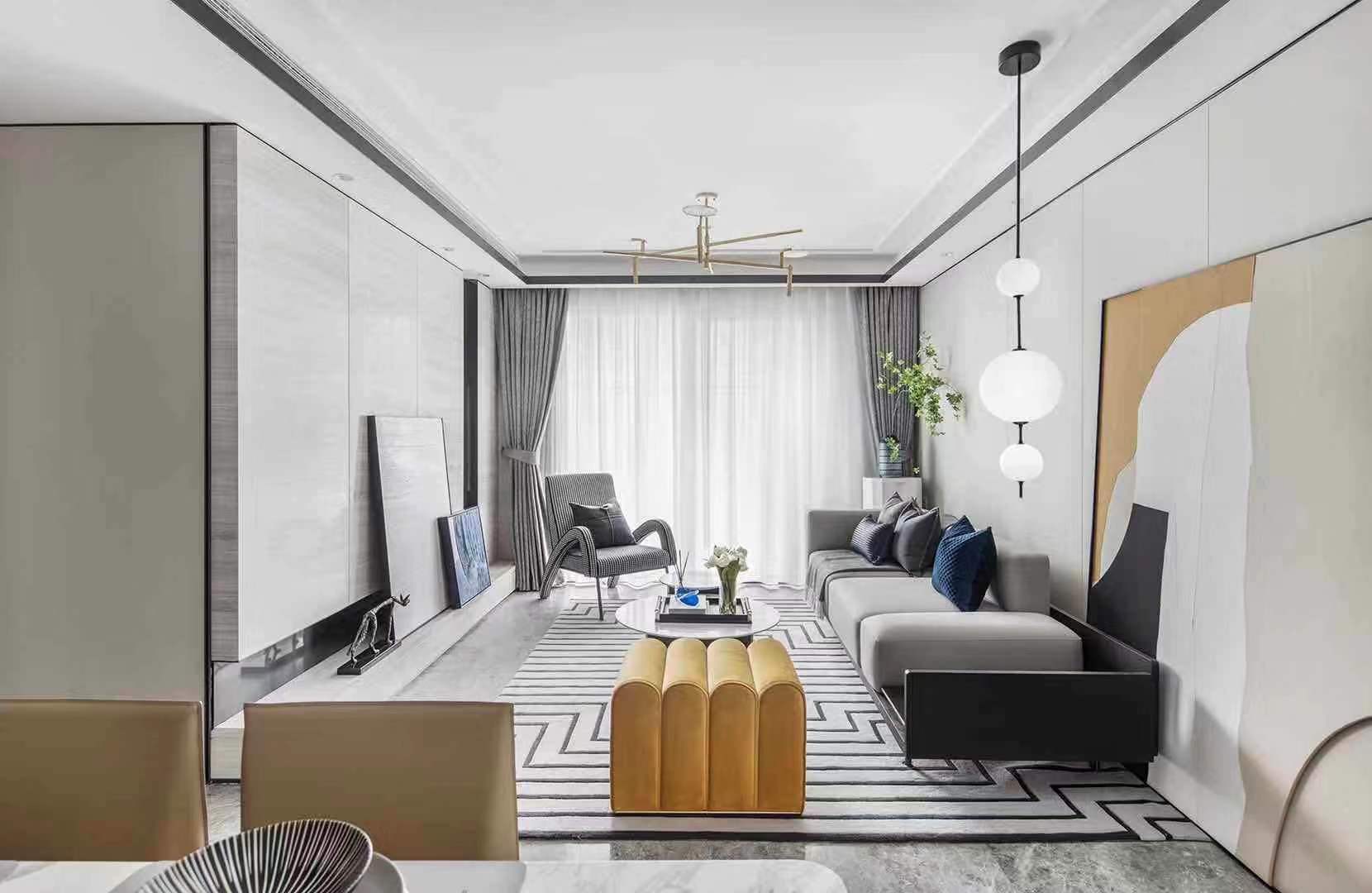  95户型以黄蓝色为主要跳色，首先来到作为主要公共空间的客厅区域。客厅的打造“心意”十足，珊瑚红沙发在经典优雅的廓形中注入了跳跃的色彩，仿佛诉说着空间独一无二的个性。茶几、单人沙发、地毯等单品以黑白灰色诠释，不仅衬托出沙发的大面积跳色，完美地将空间的优雅气质烘托而出。
