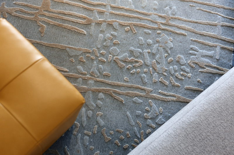 色泽柔和的意式现代转角沙发，姜黄色调的麂皮绒休闲椅，镜面不锈钢与通透玻璃搭配的茶几，丝质抽象线纹地毯，都以一种极其谦逊的态度与空间完美契合