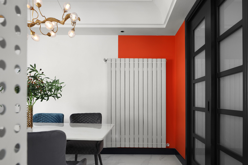 一角的暖气片成为墙上的一道风景线，珊瑚橙墙面与宝石蓝餐椅，融入的是简简单单的舒适感。
