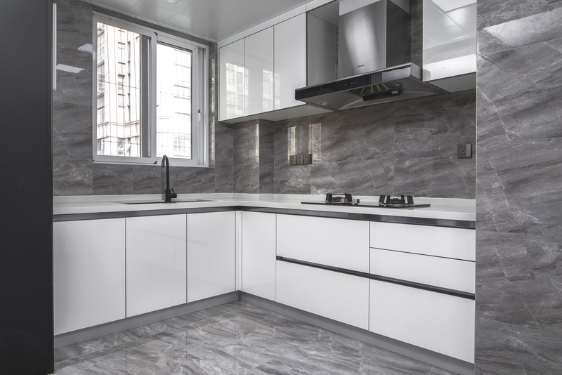 半开放式厨房和餐厅连通，加上灰色的主色调，使得空间更为宽敞明朗。白色的柜体搭配米色石英石台面，安全又环保。墙面和地面用的同是灰色瓷砖，整体色调统一。