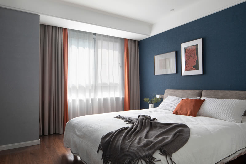 蓝灰与橘色的撞色搭配，作为卧室的主色调令人眼前一亮，合理的米灰色和白色的加入又让整个空间沉静下来。