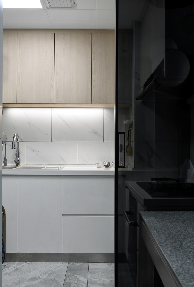 ▲厨房
厨房相对狭小，墙面设计为白色瓷砖，木色吊柜，让空间多了一份温馨。