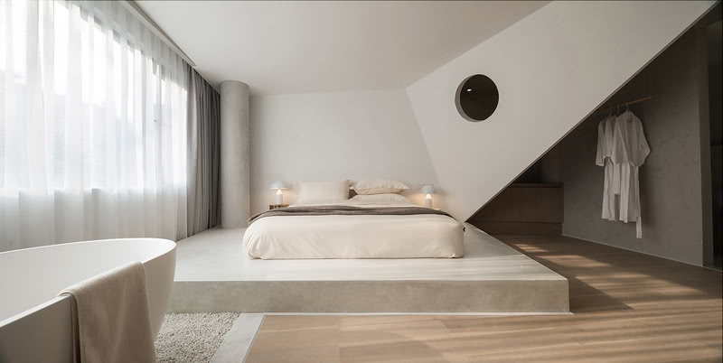 床边的鸟翼造型墙体将空间的功能区划分开来，延伸了空间感。
