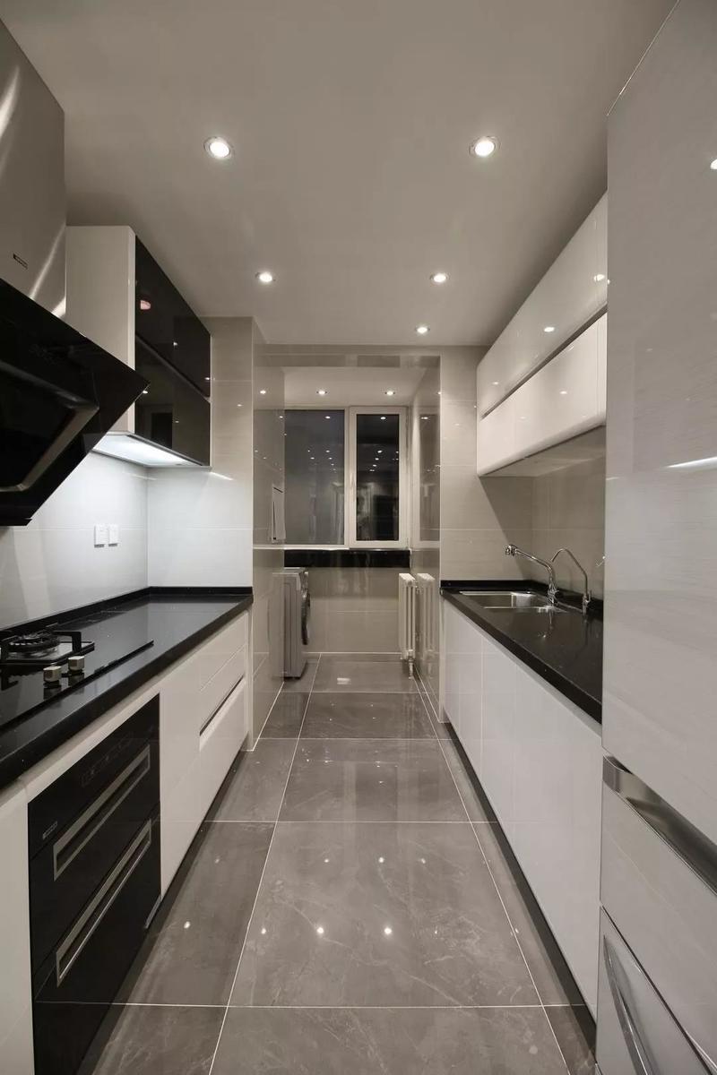 厨房的材质色调选择上也跟整体风格保持了统一，黑色台面搭配白色烤漆橱柜，以灰砖衬托，最大程度上的增加里厨房收纳空间。