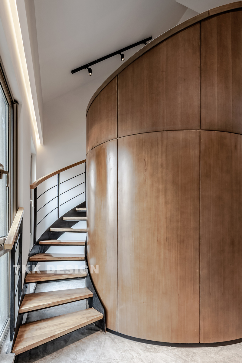 围绕柱形的个性弧形旋转楼梯盘旋而上，镂空台阶悬空设计让空间看起来更简约，精致，很适合小户型设计。