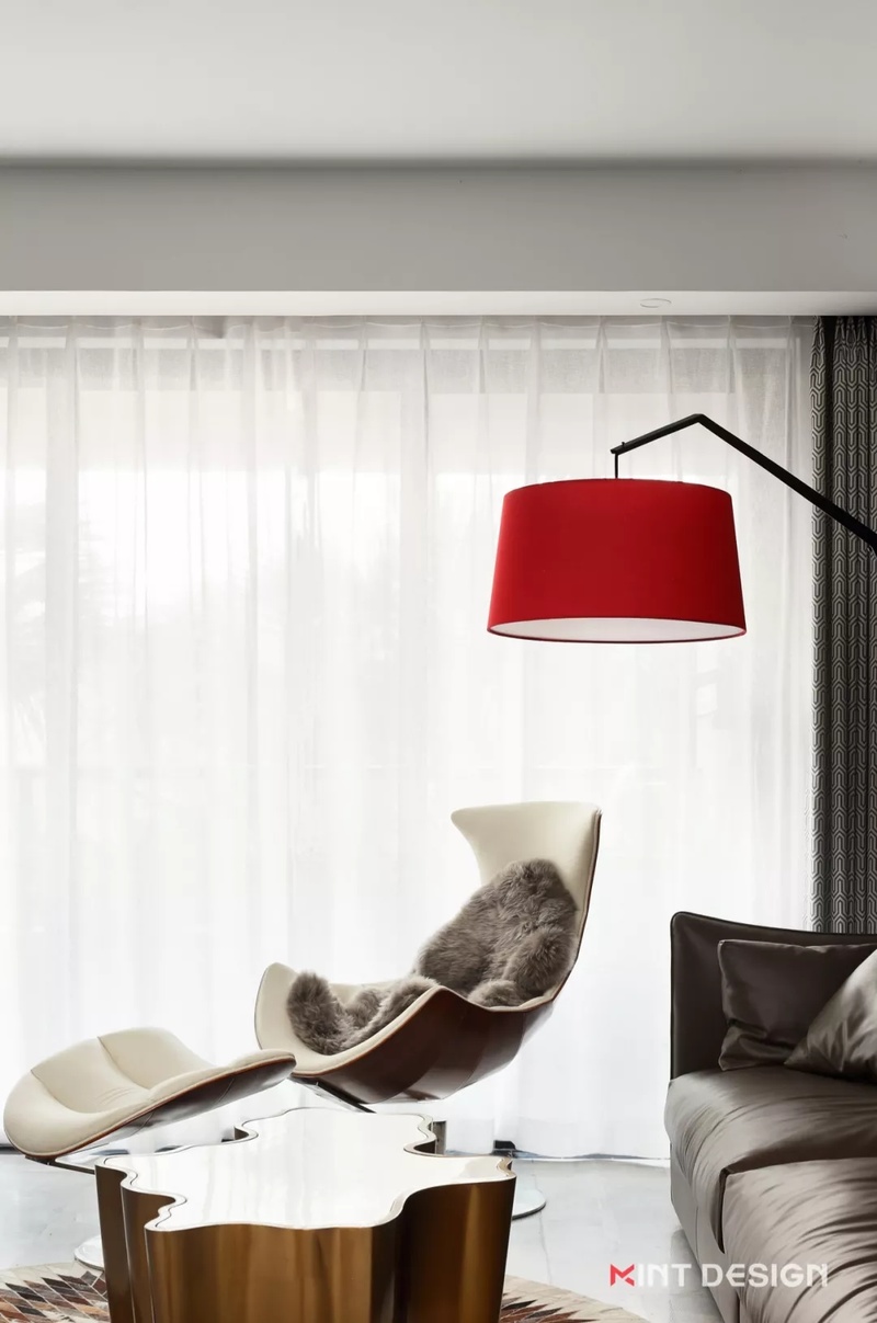 红色吊灯提升了空间的亮度，搭配来自丹麦的乳白龙虾椅，自然的划分出了一个单独的区域，给人宁静悠闲的氛围，用来小憩或阅读再好不过。