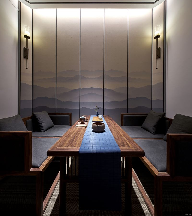 茶室以一幅重峦叠嶂的远山为背景，给人以宁静、赋有诗意的空间；宝蓝色的茶巾与之背景交相辉印。