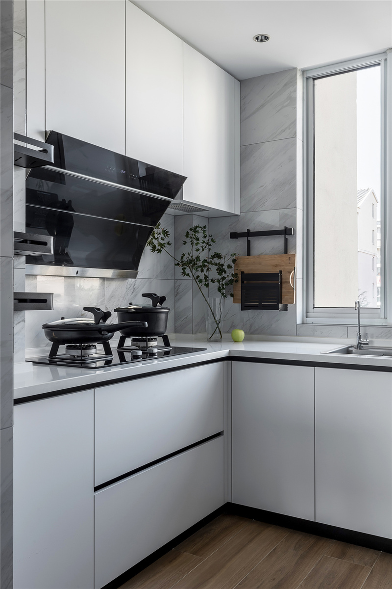 半开放式的厨房，以白色为主调；让空间更为简洁明亮，将冰箱半嵌，让厨房与餐厅的活动区域变得更流畅。