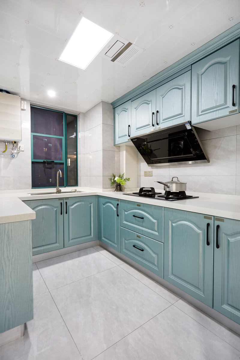 厨房的墙面嵌以美式田园浅蓝白色的立柜，将空间最大化利用，辅以灰瓷装点墙面，统一整体色调，提亮空间，美化视觉感。