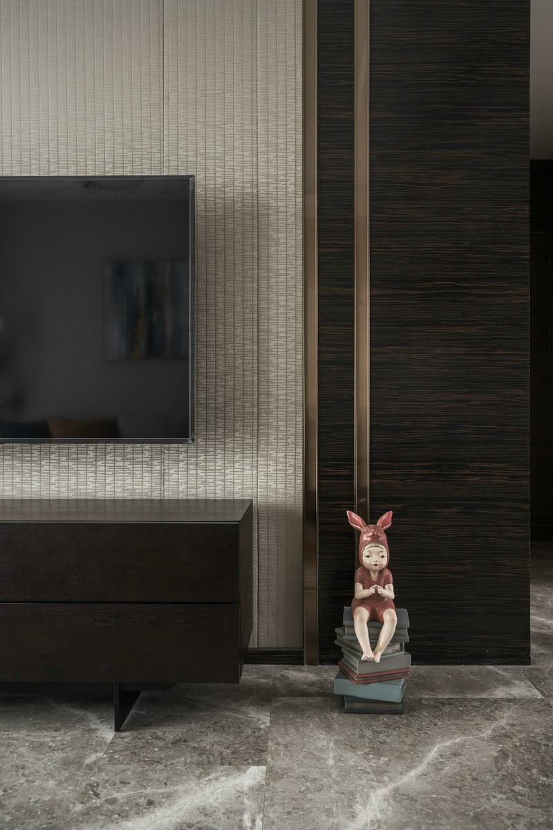 深棕色框架电视柜，搭配灰蓝色点缀柜门和门板缝隙，置于原本两边深中间浅的电视背景墙中，空间瞬间灵动起来，避免了平淡呆板。
