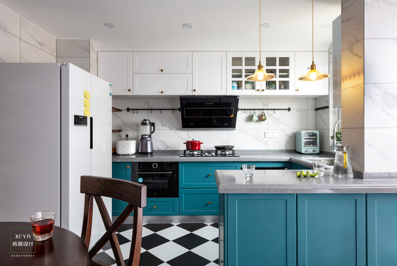 厨房间淡雅蓝绿色门板，配上黑白砖。好看而且最主要的功能齐全，内嵌烤箱，蒸箱洗碗机都有了，食物的色泽让干净清爽的厨房区多了生活的气息。