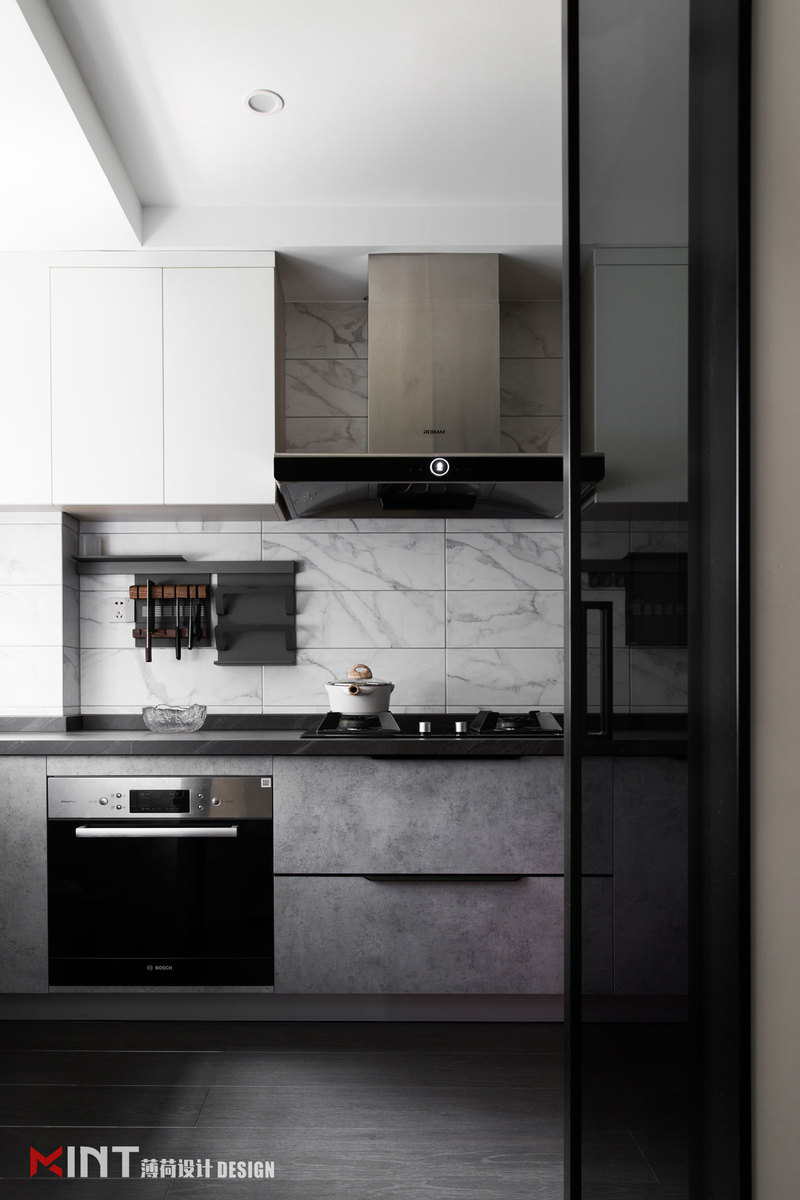 厨房 
厨房用硬朗简洁的直线条和深深浅浅的莫兰迪色系，营造了空间的层次感， 光洁的收纳柜与金属质感的家电，将时尚感与实用性完美结合。