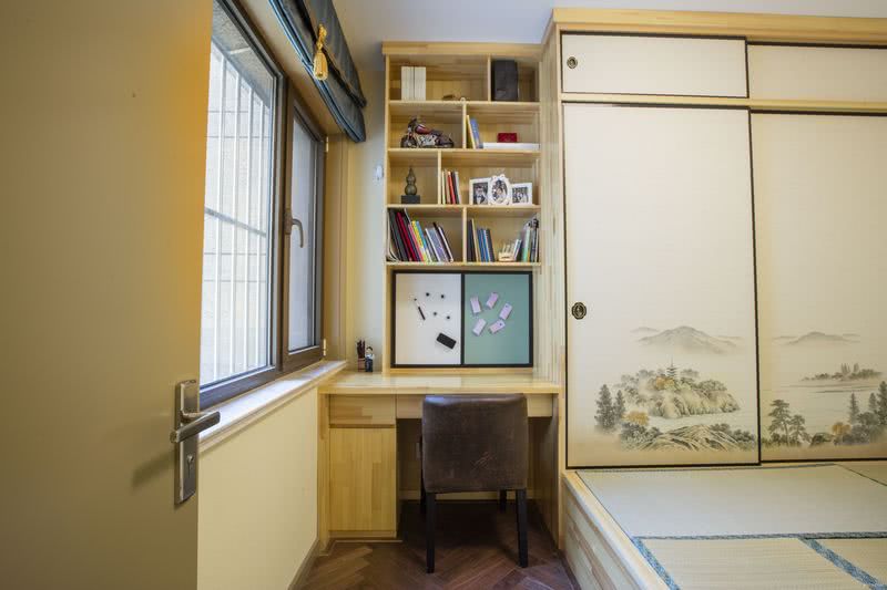 卧室延续整体柔润的木质调性，由窗边延伸出一方开放空间，以不同的色彩将领域切分，摆上坐垫及一张小几，日光从百叶窗微微透入，佐上一壶绿茶。