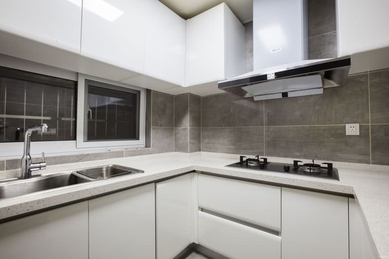 厨房位于空间的角落处，黑白色的简洁搭配，营造出视觉上的干净利落。