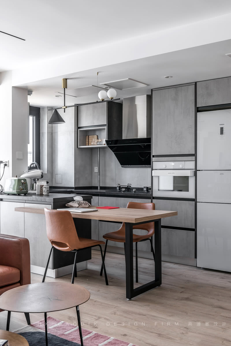 开放式L型厨房+岛台餐桌一体，嵌入式电器与整体橱柜结合的设计，大大增加了厨房的使用面积。岩板、黑色金属烤漆、原木提升空间质感。