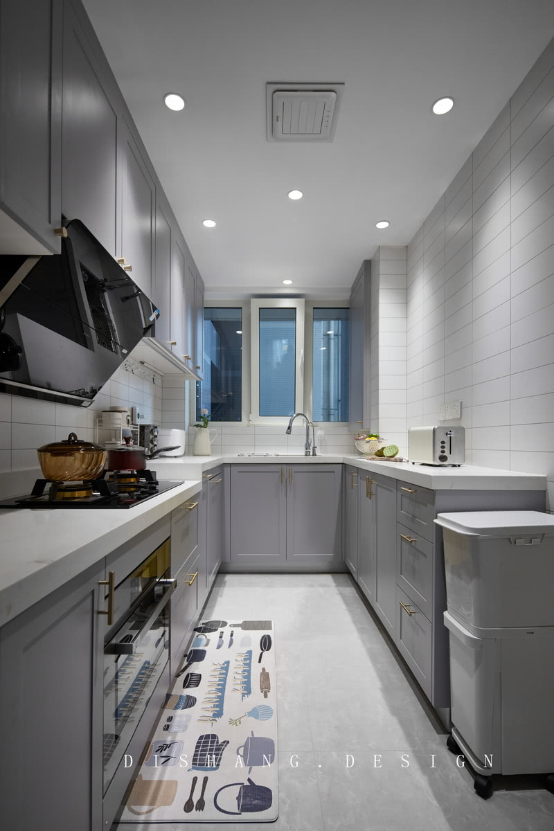U型厨房增加台面操作面积，基本功能齐全，划分明确，操作动线更加合理流畅；灰紫色与白色搭配，加上金属把手的设计，空间温柔而高级。
