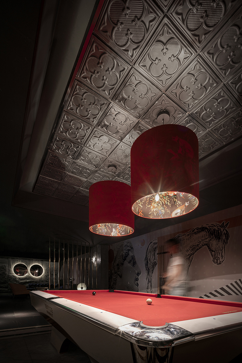 桌球娱乐区采用红色做跳跃颜色，吊灯采用动物图案，点睛桌球区的视觉效果。