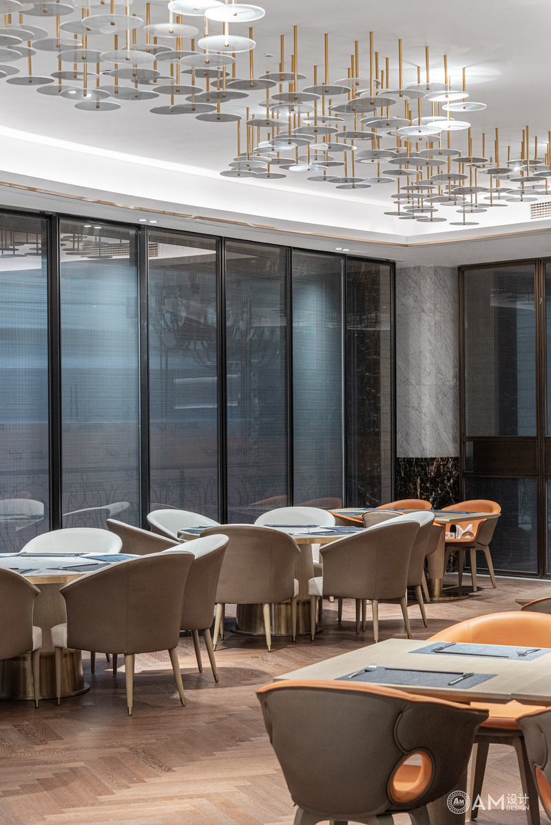雷雨明设计|沧州渤海酒店餐厅用餐区设计
不同的材质在空间中综合运用，不同的肌理所形成有节奏的韵律感，明快通透的组合形式组成室内空间。在顶端灯饰选用上，我们选用透明亚克力，如蜻蜓点水一般，点缀整体的大厅空间。尽可能减弱现有空间局促感，增强空间的表现性。