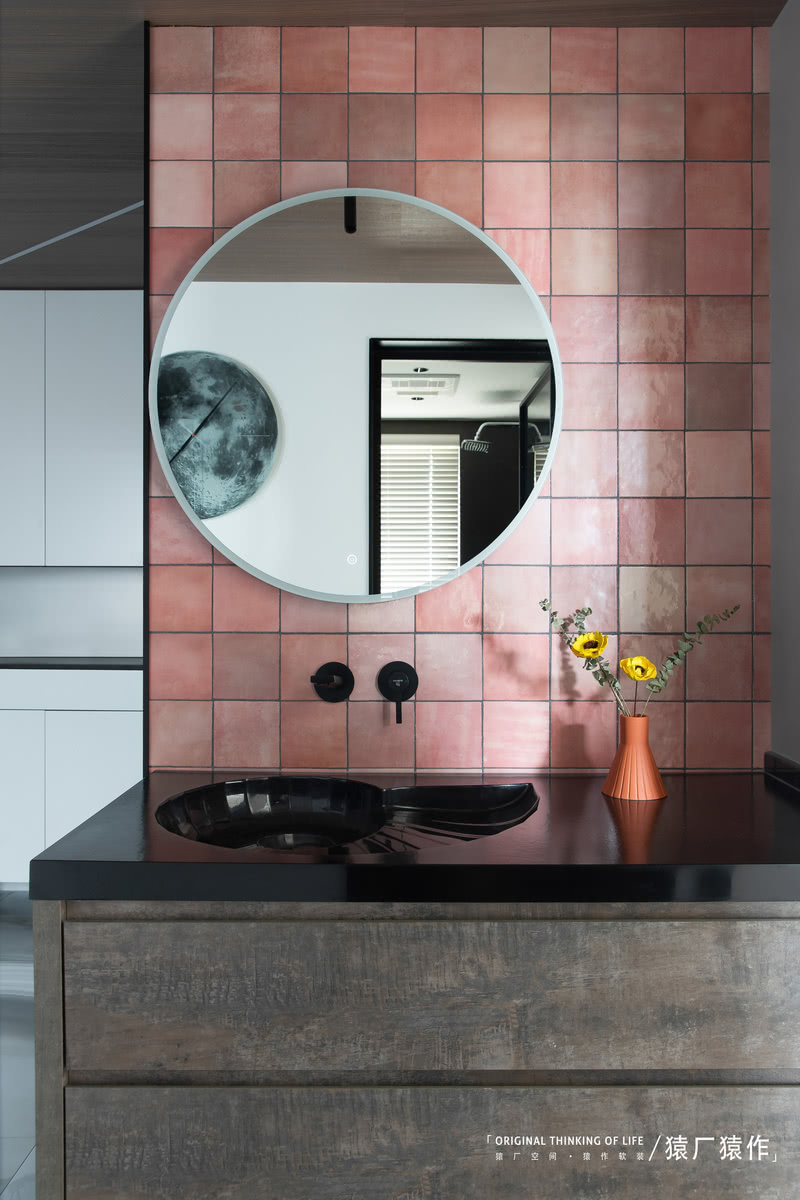 玄关处全身镜背后，粉色的马赛克搭配黑色的螺旋海螺式的洗手盆，又是一番独特风景。