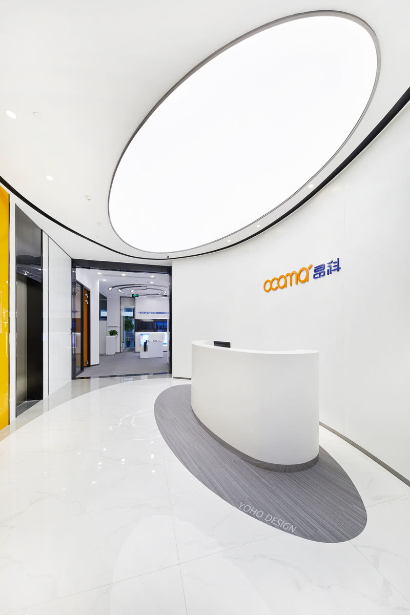 以大面积的定制弧形铝板材料作为背景，传达简洁、干净的特点；综合电梯墙面的LOGO橙色彩做呼应，形成具有强烈企业属性的韵律感。