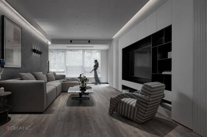 客厅黑白灰三种色调，纯净极简，传达现代的气息；加上天然的木质、柔和的布艺、金属等材质，散发出台式特有的成熟内敛气质；独特的艺术摆件、装饰画、灰色布艺沙发，营造轻松舒适的客厅环境。
