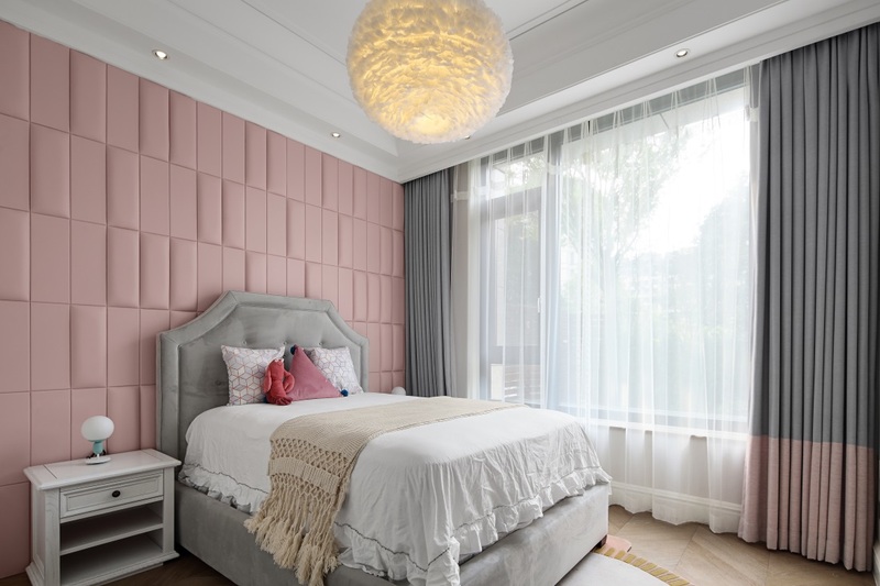 粉色马卡龙主题的卧室，凹凸变化的背景搭配粉色窗帘的细节，轻盈的羽毛灯更增添少女的浪漫情怀；