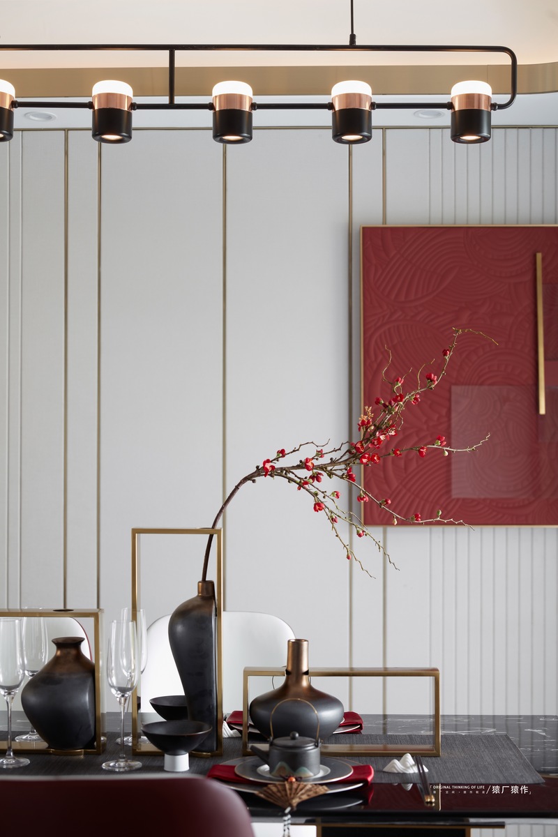 大理石+金属融合而成的新中式餐桌，轻奢之余，更有一派家的温馨感。再加上吊灯与中国红装饰画，整个餐厅显得尤有中式古典之美。