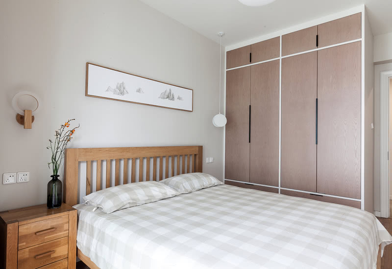 老人房延续了温润的实木质感，使用低饱和度色彩，搭配棉麻质感的床品，为老人提供兼顾舒适与美感的空间。