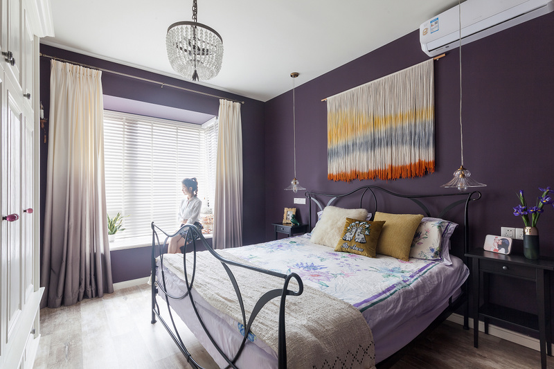 和客厅书房跳脱的色彩想比，主卧采用优雅深邃的烟灰紫，在这样静谧的环境下，很容易进入深睡眠。紫色渐变窗帘与木百叶提亮空间，墙壁上的挂毯，成为空间的点缀。