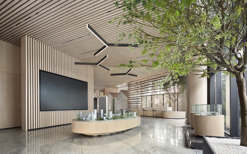 沙盘区悬挂富有极简主义的卡萨龙吊灯，像树枝一样向外舒展，让整体空间也得到延伸，添具一份现代抽象美感