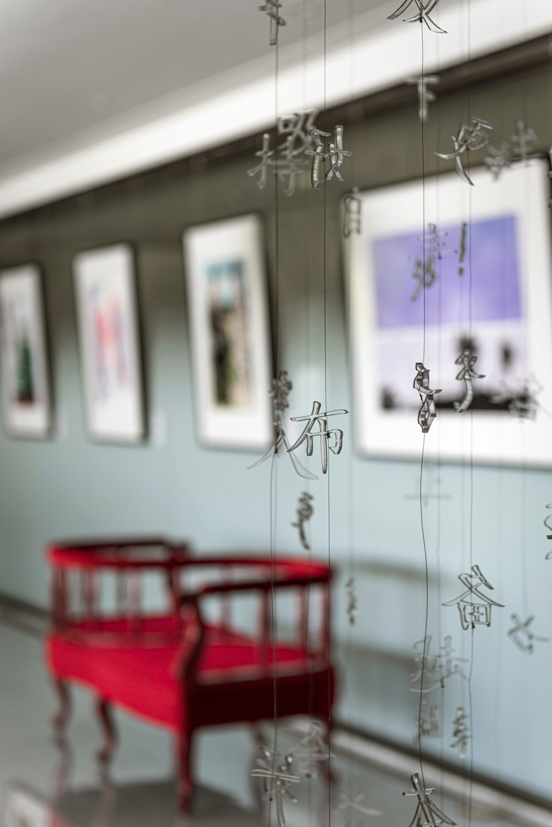 随着动线而入是艺术过廊，将画廊的形式与办公空间结合，为人在空间的行为带来视觉上的独特效果，每一幅艺术画的选择都与服装公司的价值观相契合。红色情人椅既像一个艺术品一样静静安放在这里，又吸引着人坐下细品墙上的艺术品。