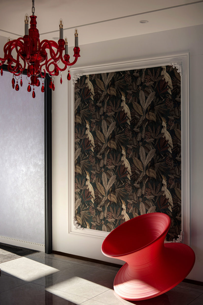过廊尽头将热带植物壁纸以艺术画的手法展示，红色Spun陀螺椅细腻的线条纹路带来了如同旋涡的吸引力，整体充满了雕塑般的美感。红色水晶灯华丽而神秘。
