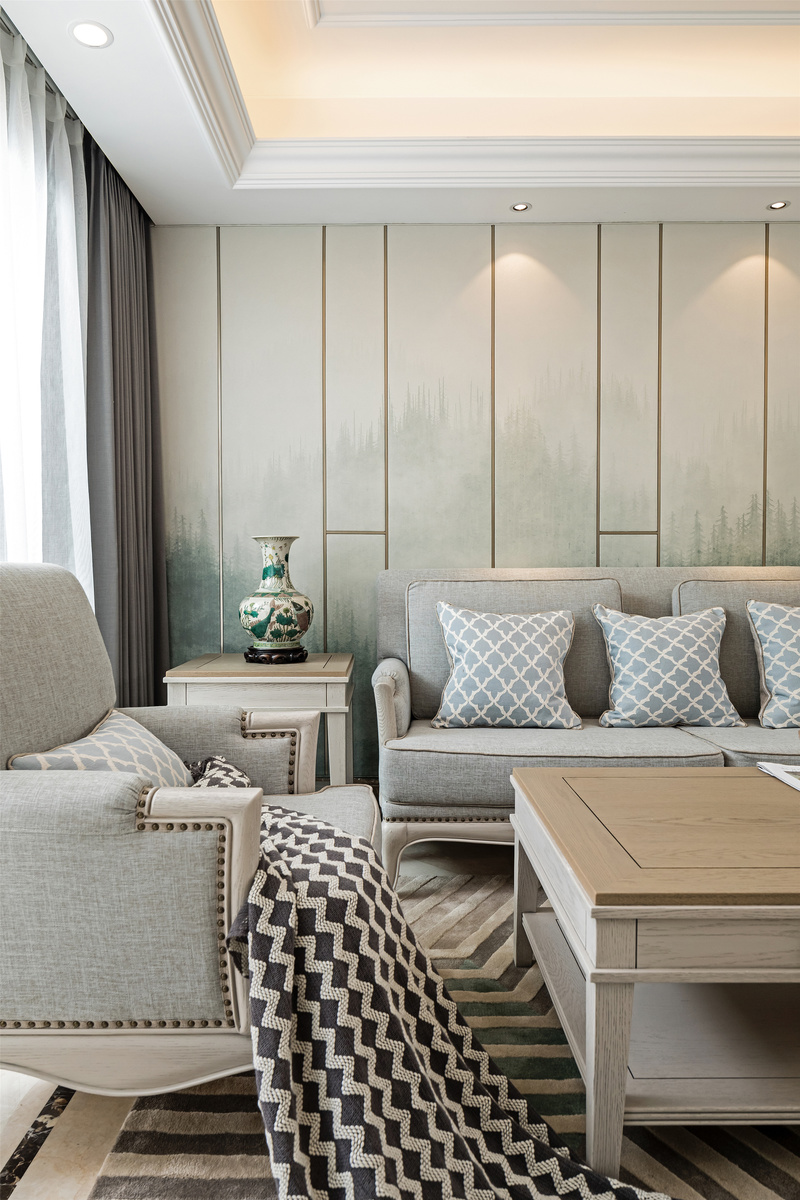 冰川灰色的沙发搭配雨灰色地毯，
同一色系不同纯度之间体现出丰富的层次。
以简化的石膏线、硬包加以图案装饰，
打造出极富典雅魅力的墙面背景。
配合艺术品装饰渲染氛围，
整个空间配置虽然简单，但情调十分诱人。