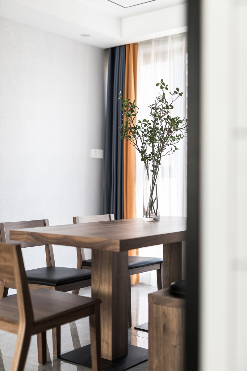 餐桌椅木作与皮质的配合恰到好处，挑选浅木色餐桌和深色坐垫，增添就餐氛围。