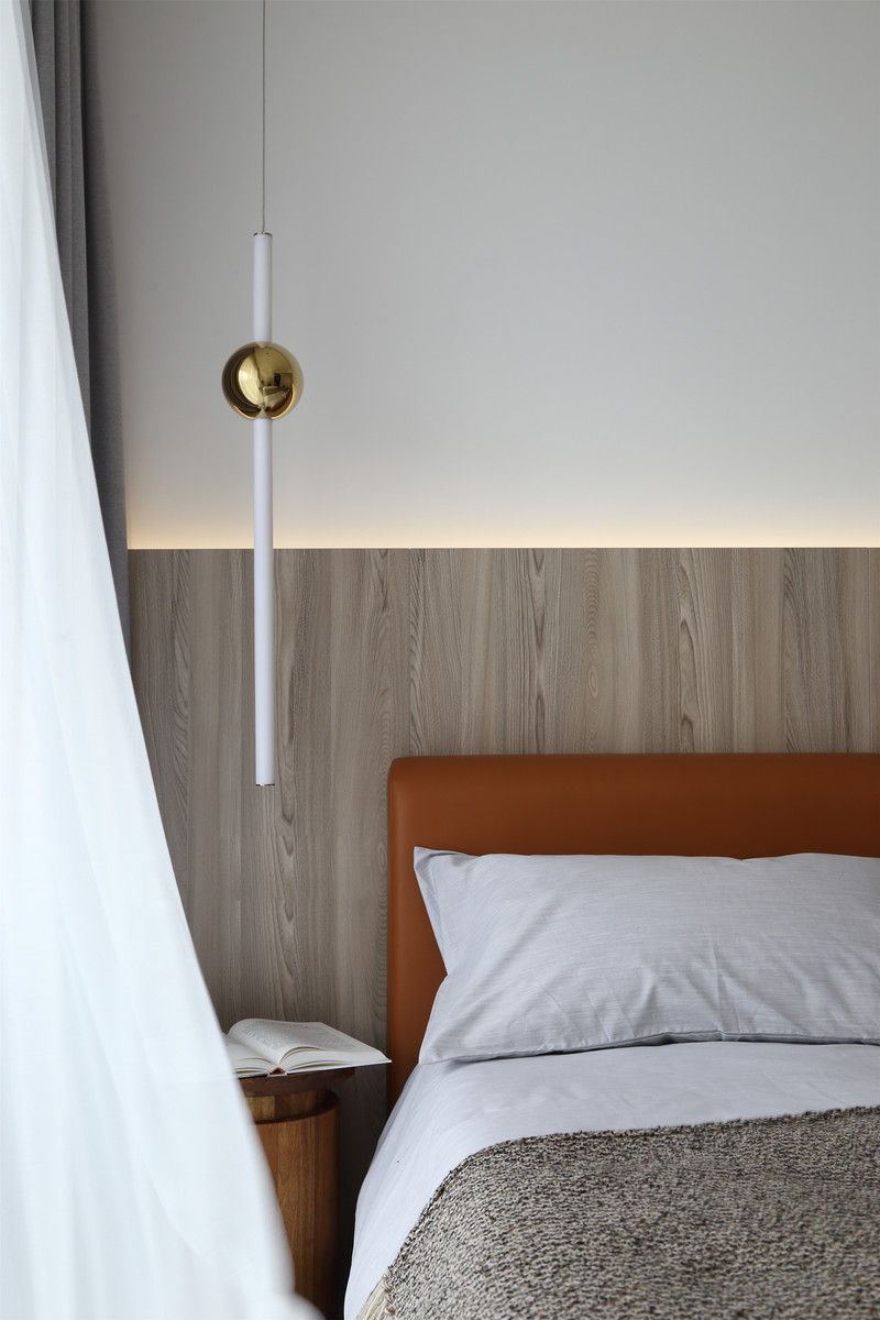 次卧以休闲简约为主线，床头的一抹橘色成为空间内的点睛之笔，让室内氛围更加轻快明朗。床边的置物柜具有充足的储物空间，满足了客人来访时的存储需求。
