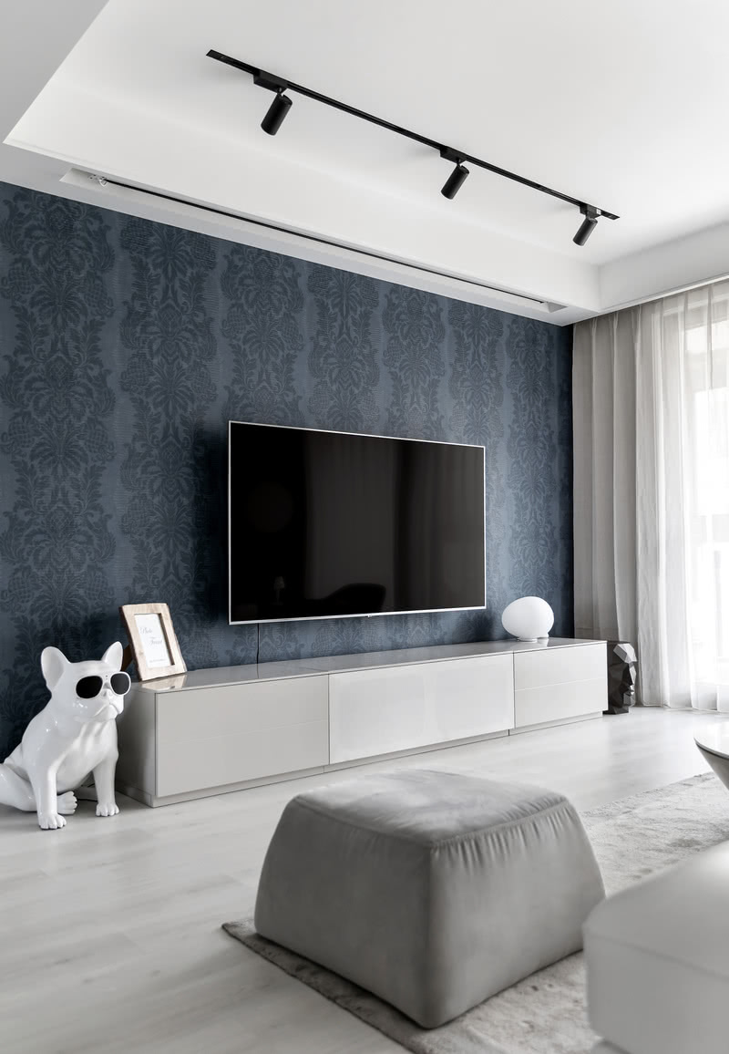 电视背景墙选择了丹宁蓝复古花纹的壁纸，
色彩的明暗变化谱写空间韵律。