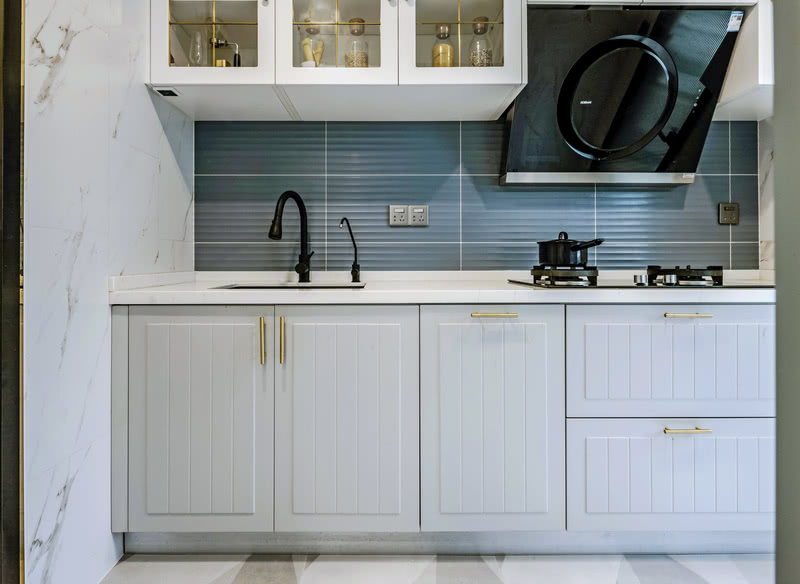 厨房一字型操作台面，整体橱柜白色为主，门把手金属色点缀增加一丝轻奢感。上面吊柜玻璃门更方便拿取厨具用品增加更多收纳。