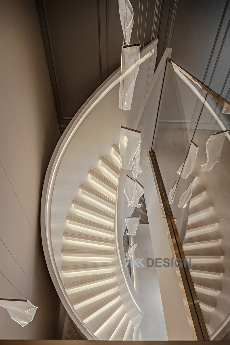 楼梯挑空的空间结构让室内呈现开阔大气之感，流线型旋转的楼梯设计，与灯带演绎出梦幻灵动酷炫的空间！从上方俯视看楼梯的呈现效果。 