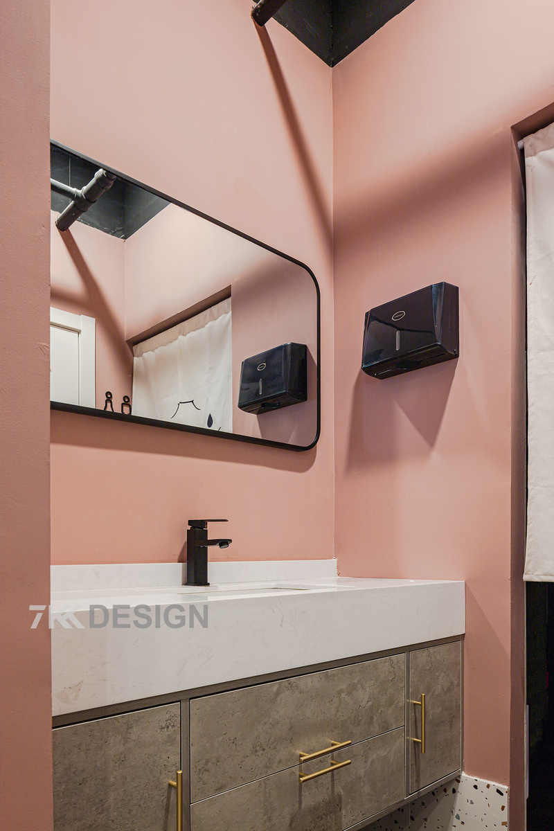 卫生间用简洁的色彩打造了具有情调的空间，马卡龙的粉色与黑框浴室镜，白色台盆，水泥色浴室柜加以金属拉手的碰撞让生活场景化，营造了一个精致，清新自然的空间。
