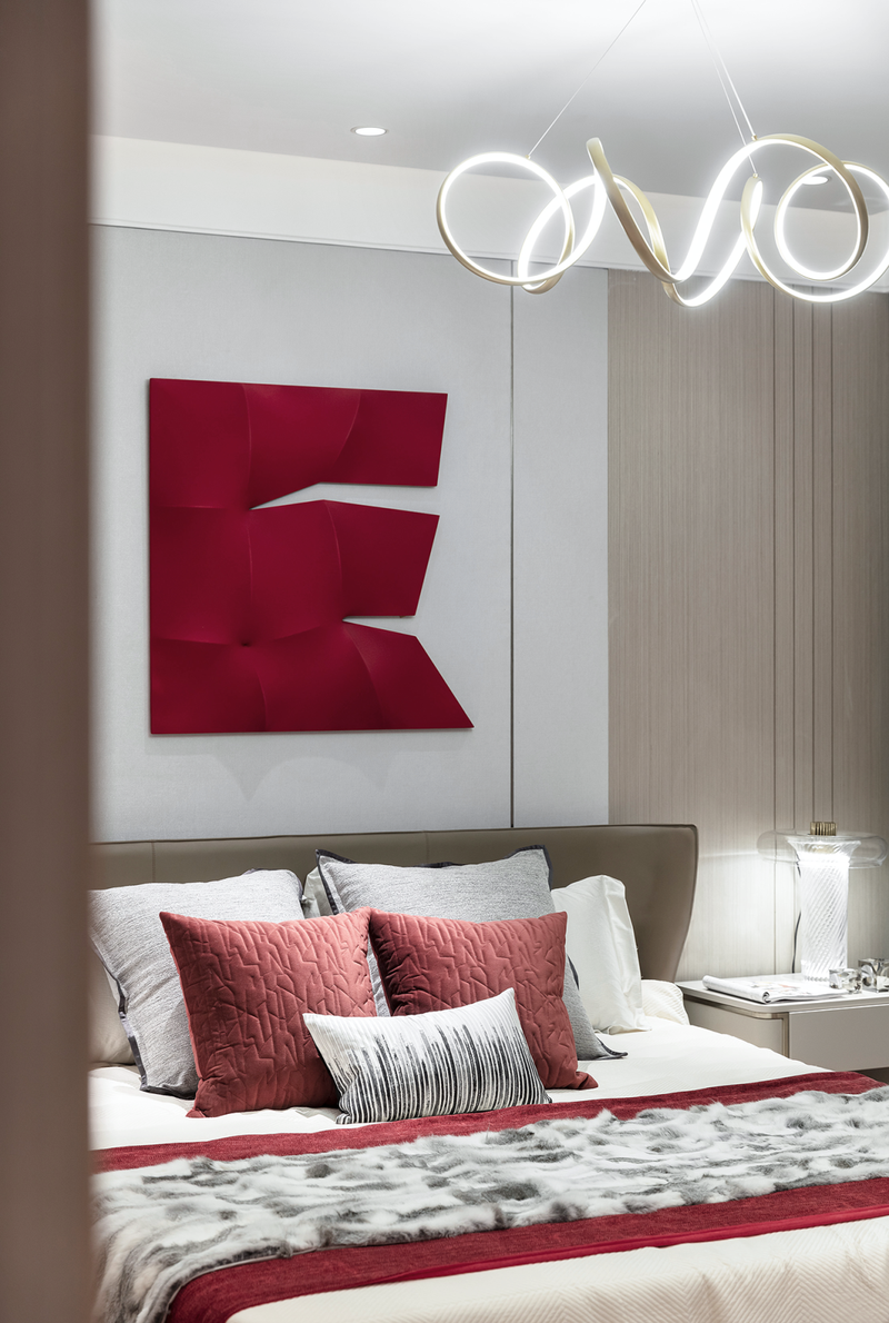 
主卧室中红色依然是最闪耀的存在，浓淡不一的红色与质朴的木形成泾渭分明的对比，在热情与内敛之间，极具曲线美的蜿蜒吊灯，以极致的优雅，中和了空间的气质，色彩浓度及材质的调制，一切都恰到好处。