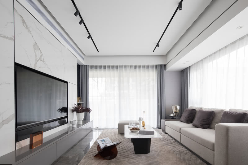 客厅整体空间简洁明亮，选用黑白灰为主色调，少量暖色点缀其中，家具与饰品元素的融合恰到好处。光影给空间添加了丰富性，给人带来宁静，温柔的舒适感。