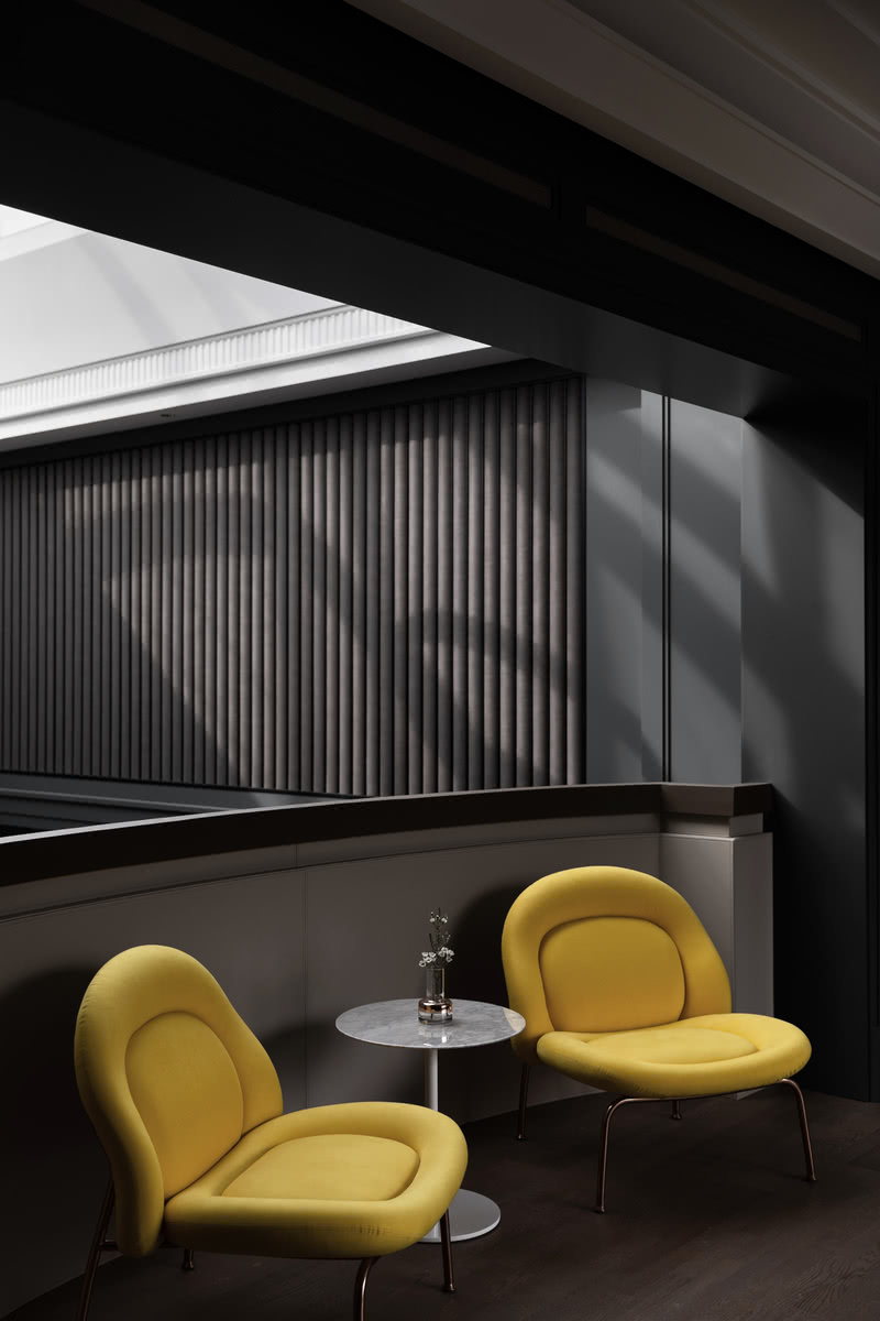 二层和一层会客厅的互动平台用两个亮黄色的椅子作为点缀，在暗调墙板的衬托下显得淘气又可爱。在阳光的照射下异形钢结构形成的流线型光影，随着太阳位置的变化而变化，像极了原始放映机的效果。