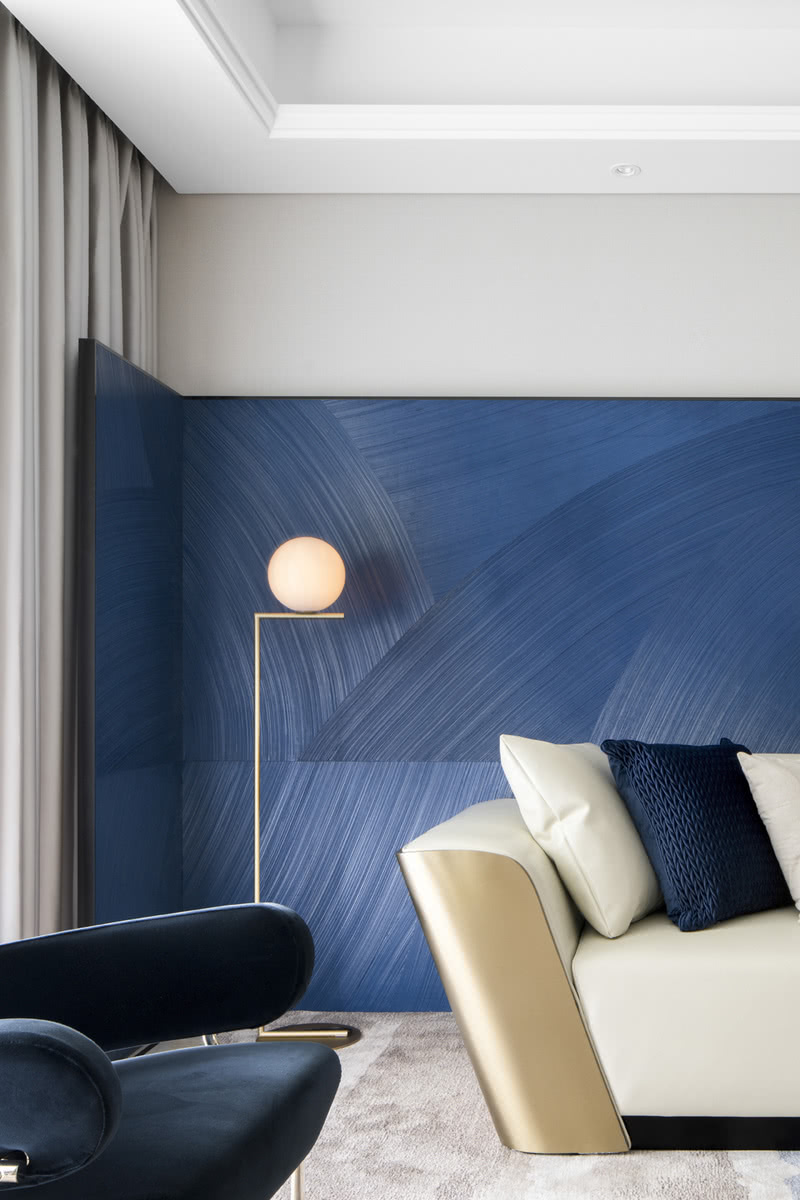 客厅屏风大面积蓝色调以及几何线性的肌理，与浅色系的皮革沙发，布艺的休闲椅，哑光复古的咖啡桌交相呼应。