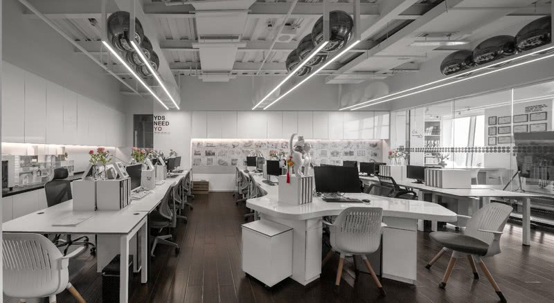 办公区开放布局搭配黑白色彩、简明工位，彰显出设计工作的理性与多元。