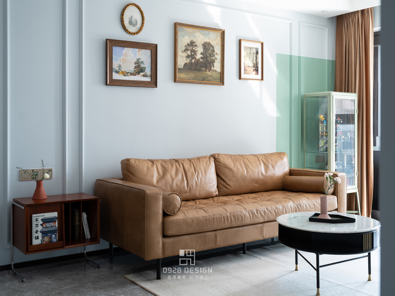 沙发选用皮质棕色小复古沙发，来自北欧表情。挂画选择组合式挂画，手绘油画，黄铜边框，复古中带有小清新