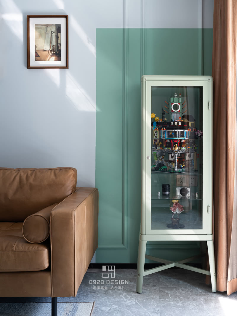 手办柜来自宜家，小清新的绿色和背景绿色油漆同色系，与沙发与窗帘撞色，圆角的造型使得感受更加温和。