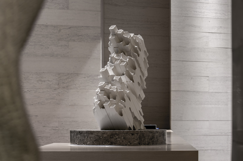 抽象雕塑矗立在灰色大理石台上，是整体空间的艺术凝聚点。请输入图片说明